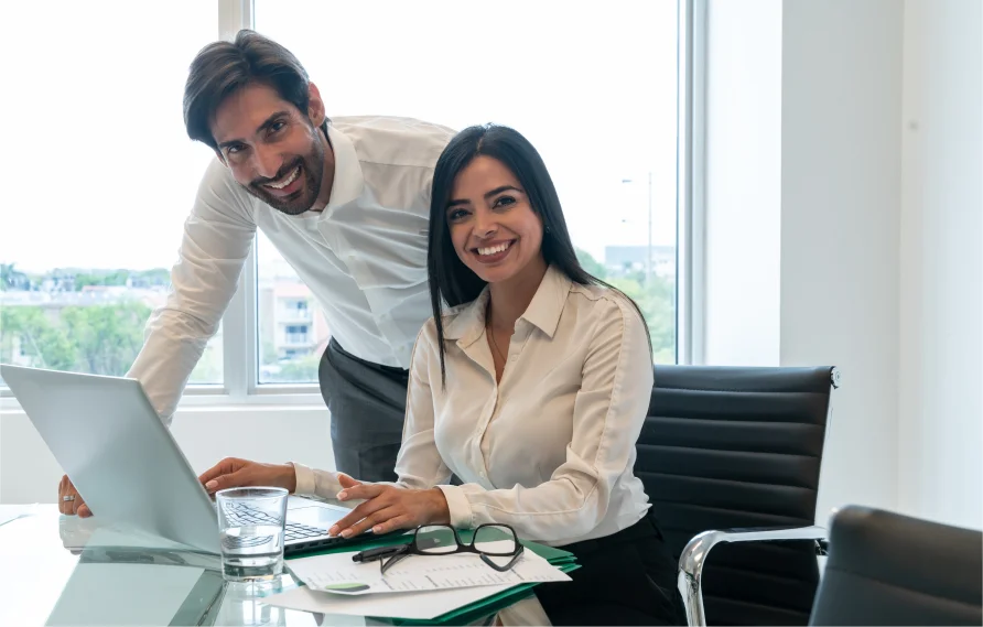 An office scene with a diverse group of professionals, two shaking hands, smiling, near a Centific logo.